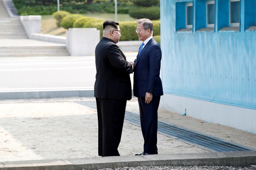 El líder norcoreano, Kim Jong-un (i), y el presidente surcoreano, Moon Jae-in (d), estrechan la mano durante un paseo por la Zona Desmilitarizada en Panmunjom (Corea&nbsp;del Sur).&nbsp;
