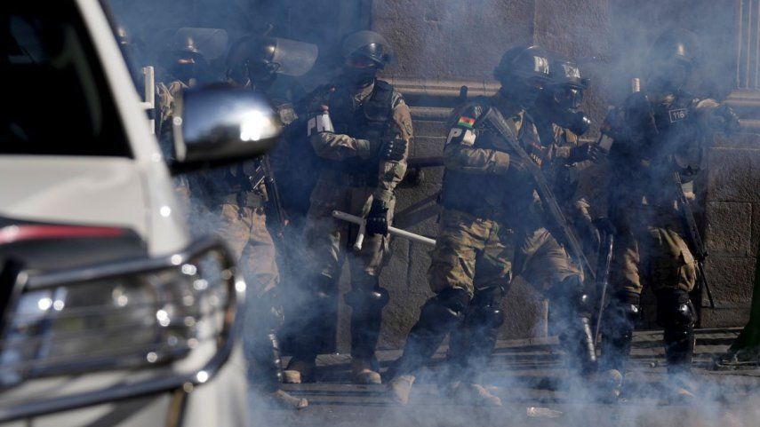 La policía militar se encuentra en medio de gases lacrimógenos que dispararon frente al palacio presidencial en la Plaza Murillo en La Paz, Bolivia, el miércoles 26 de junio de 2024.