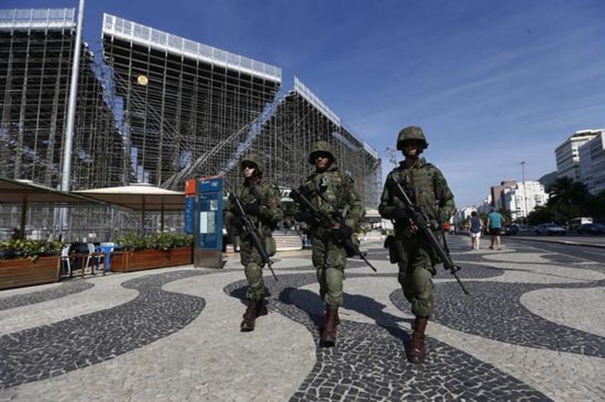 Fusileros de la Marina de Brasil caminan frente a la arena de Voleibol playa en Copacabana. (EFE)