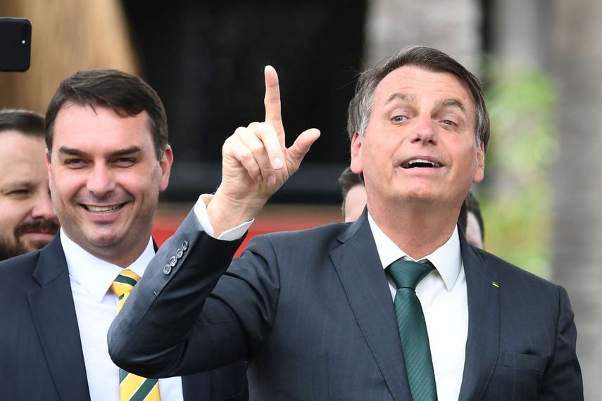 El presidente brasileño Jair Bolsonaro hace un gesto junto a su hijo, el senador Flavio Bolsonaro, durante el lanzamiento de su nuevo partido, la Alianza por Brasil, en un hotel en Brasilia el 21 de noviembre de 2019.