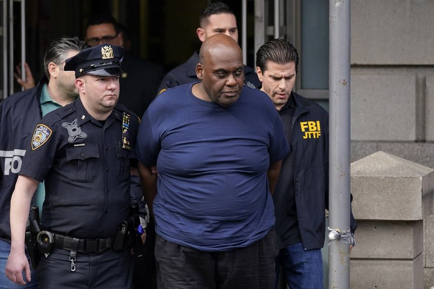 Policías de la ciudad de Nueva York salen de una comisaría con Frank R. James, de 62 años, al centro, sospechoso de un tiroteo en el metro, el miércoles 13 de abril de 2022, en Nueva York.&nbsp;