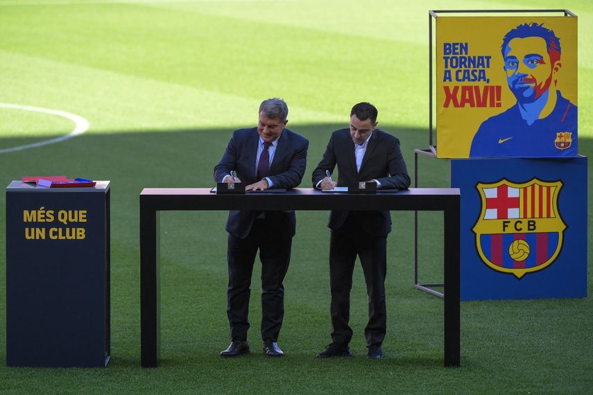 Momento exacto en el que Xavi Hernández firma el contrato junto al presidente del FC Barcelona,&nbsp; Joan Laporta,