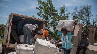 &nbsp;Personas cargan un camión con alimentos para ser entregados tras el paso del huracán Matthew