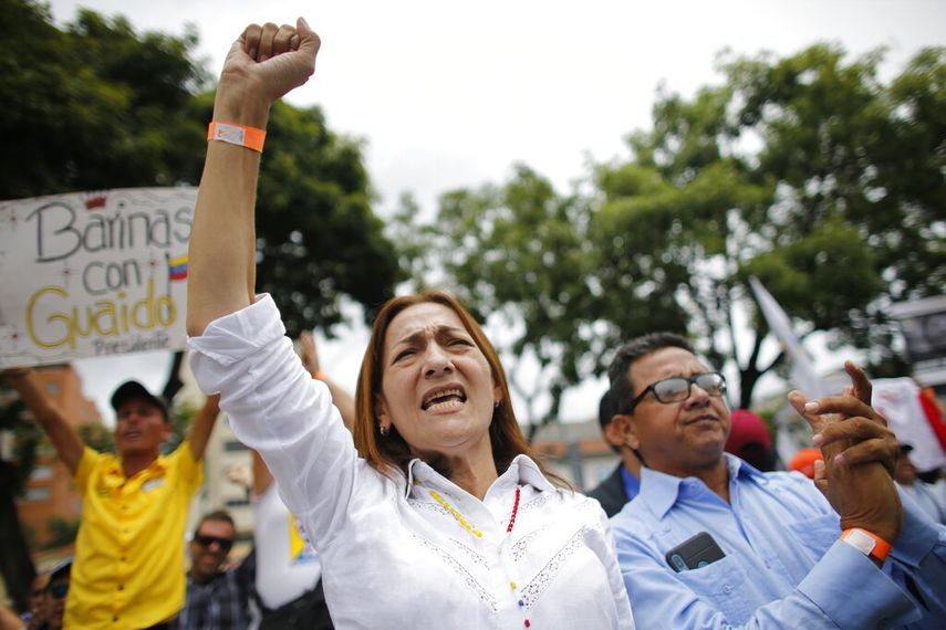 Una partidaria del presidente encargado venezolano Juan Guaidó eleva su puño durante una sesión de la Asamblea Nacional en una plaza de Caracas, Venezuela, el martes 23 de julio de 2019. 