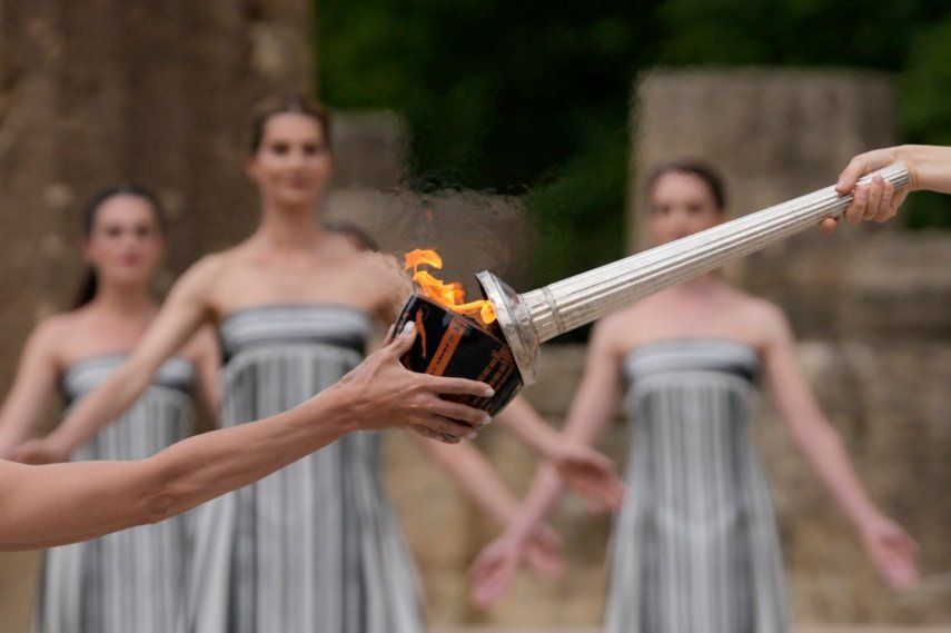 La actriz Mary Mina, que interpreta a una sacerdotisa, a la derecha, enciende una antorcha durante la ceremonia oficial para los Juegos Olímpicos de París, en la Antigua Olimpia, Grecia, el martes 16 de abril de 2024.&nbsp;