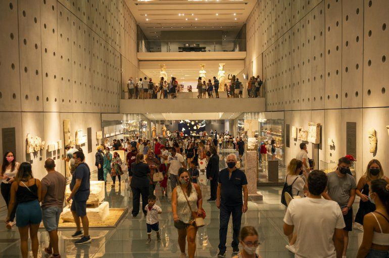 En esta imagen del 22 de agosto de 2021, el público visita la Acrópolis de Atenas. Los museos y sitios arqueológicos abren por la noche durante dos días. 