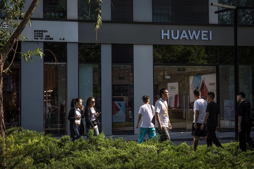 Varias personas caminan frente a una tienda de Huawei, en Pekín, China.