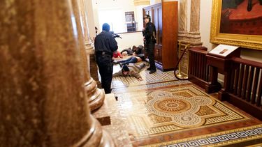 Agentes de la policía del Capitolio retienen a punta de pistola a unos manifestantes cerca del recinto de la Cámara de Representantes, en el Capitolio, en Washington, el miércoles 6 de enero de 2021.
