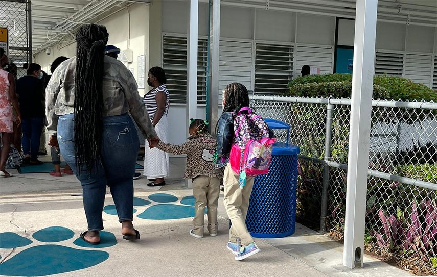 Una pequeña llega a la escuela Natural Bridge, en North Miami, de la mano de su madre.