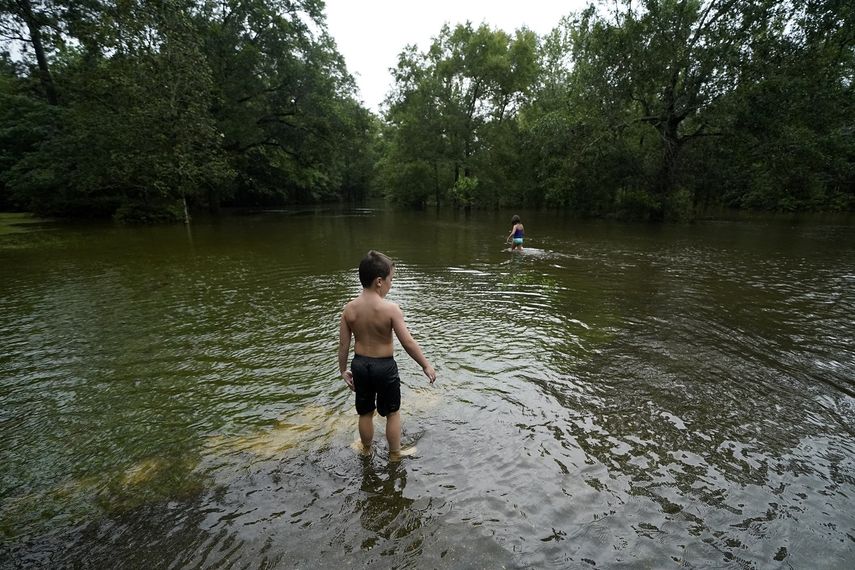 Marina Kingsmill y su hermano Raylan juegan en la calle inundada frente a su casa después del paso de la tormenta tropical Claudette en Slidell, Luisiana, el sábado 19 de junio de 2021.&nbsp;