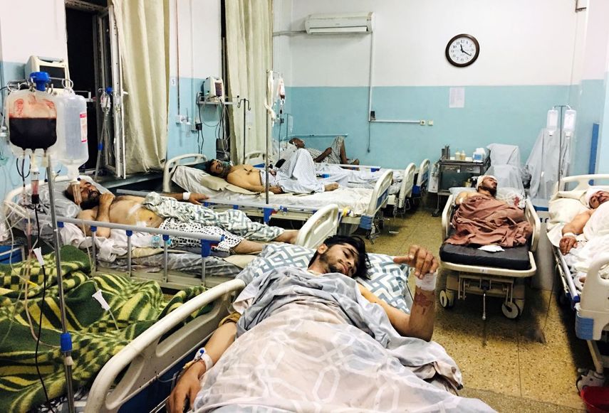 Varios afganos acostados en camas de un hospital de Kabul, Afganistán, el jueves 26 de agosto de 2021, luego de que resultaron heridos en los ataques perpetrados afuera del aeropuerto de la capital.