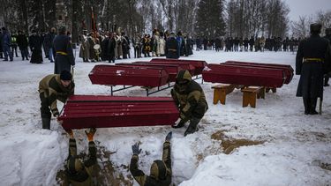 Empleados municipales sostienen un ataúd que contiene restos de soldados rusos y franceses durante una ceremonia de entierro en la ciudad occidental de Vyazma el 13 de febrero de 2021. Funcionarios y descendientes de líderes militares rusos y franceses del siglo XIX se reunieron para una ceremonia azotada por el viento en la ciudad occidental de Vyazma para volver a enterrar los restos de 126 personas muertas en una de las batallas más sangrientas de la campaña rusa de Napoleón.