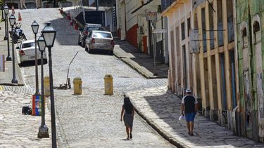 Unas personas caminan en una calle vac&iacute;a durante el confinamiento impuesto por el gobierno local para frenar la propagaci&oacute;n del nuevo coronavirus en Sao Luis, en el estado de Maranhao, Brasil, el martes 5 de mayo de 2020.