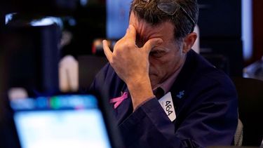 El operador bursátil Gregory Rowe trabaja en el piso de remates de la Bolsa de Valores de Nueva York.