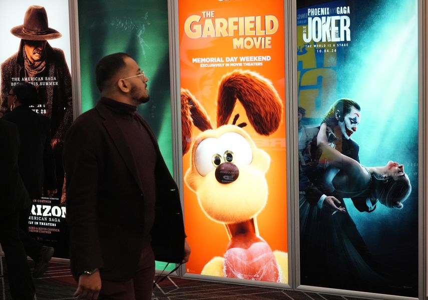 Un asistente pasa junto anuncios de próximas películas, incluidas The Garfield Movie y Joker: Folie a Deux, el día inaugural de CinemaCon 2024 en el Caesars Palace, el lunes 8 de abril de 2024, en Las Vegas.