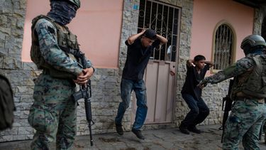 Soldados obligan a dos hombres a ejercitarse como castigo por no tener permisos para sus motocicletas, en la ciudad de Durán, ubicada frente a Guayaquil, Ecuador.