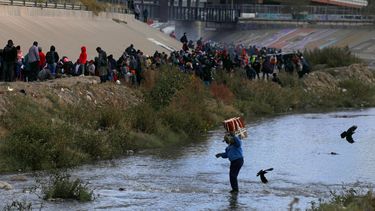 Migrantes cruzan el Río Grande para entregarse a los agentes de la Patrulla Fronteriza de EEUU en El Paso, Texas, visto desde Ciudad Juárez, estado de Chihuahua, México.