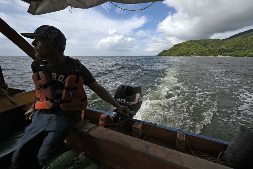 El capitán de un barco pesquero navega frente a la costa mientras participa en la búsqueda de víctimas de un naufragio en Guiria, Venezuela, el 18 de diciembre de 2020, en el que perecieron 29 venezolanos que huían de su país en búsqueda de trabajo y comida.