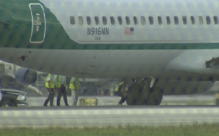 Empleados de American Airlines reponiendo el neumático del avión que sufrió la emergencia.