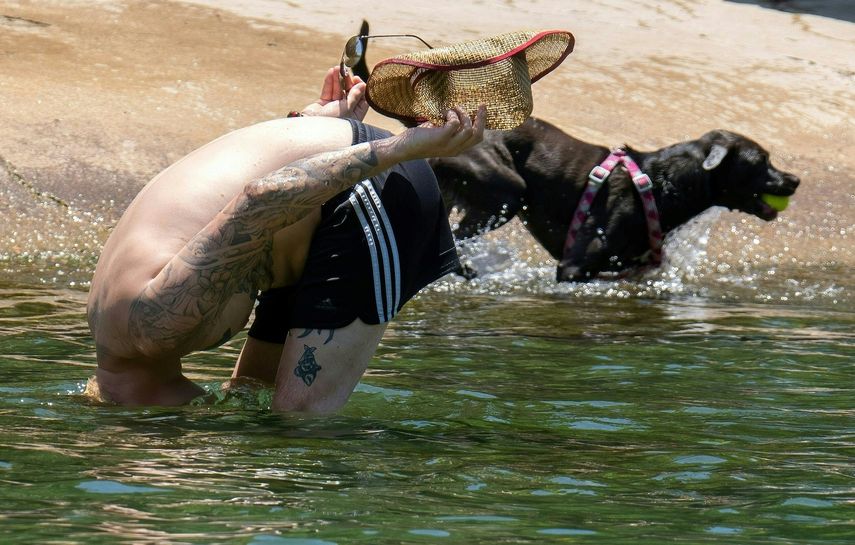 Un hombre sumerge la cabeza para refrescarse en Barton Creek Pool el 27 de junio de 2023 en Austin, Texas.