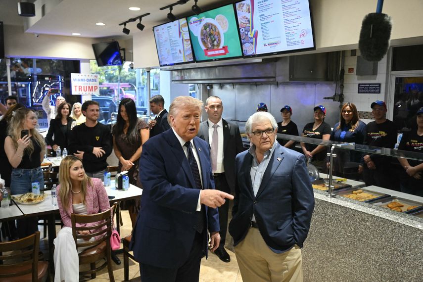 El presidente de Estados Unidos, Donald Trump, habla con el dueño del restaurante Max Alvarez en el restaurante venezolano El Arepazo en Miami, Florida, el 9 de marzo de 2026. 