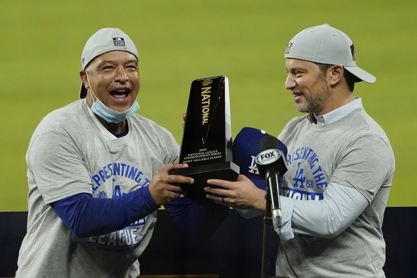 El manager de los Dodgers de Los Ángeles Dave Roberts (izquierda) y el presidente de operaciones de béisbol Andrew Friedman con el trofeo de campeones de la Liga Nacional en Arlington, Texas.