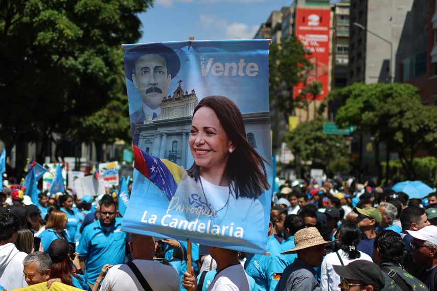 En Venezuela, una personas sostiene un cartel con la imagen de la líder María Corina Machado durante una concentración en Caracas para llamar a elecciones. &nbsp;