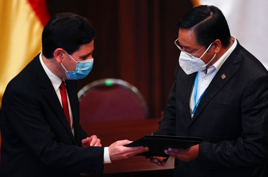 El presidente electo Luis Arce, a la derecha, recibe sus credenciales presidenciales de manos del presidente del Tribunal Supremo Electoral, Salvador Romero, durante una ceremonia en La Paz, Bolivia, el miércoles 28 de octubre de 2020.