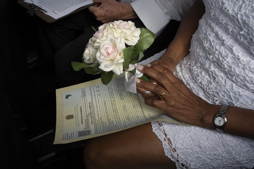 Una novia sostiene un ramo de flores durante su boda en el drive-thru de un registro en el vecindario de Santa Cruz, R&iacute;o de Janeiro, Brasil, el 28 de mayo de 2020. Las parejas comenzaron a recurrir a esta forma poco convencional de contraer matrimonio en una notar&iacute;a en Santa Cruz desde el inicio de la pandemia en el pa&iacute;s.