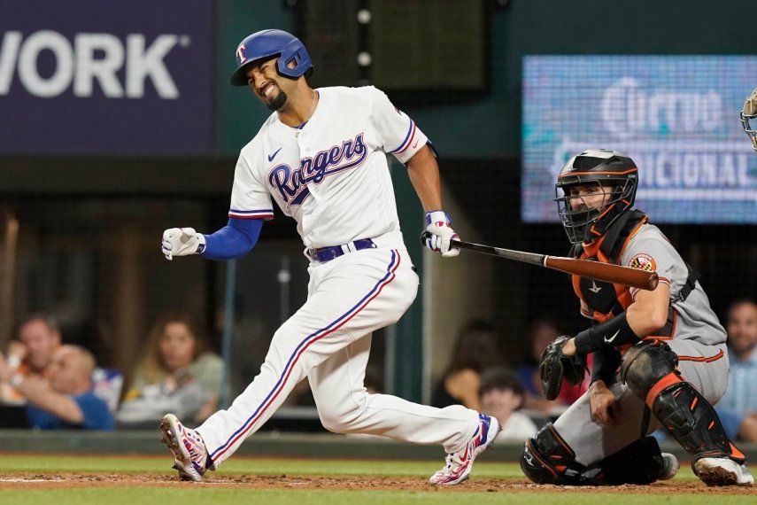 En foto del lunes 3 de abril del 2023, Marcus Semien de los Rangers de Texas reacciona frente al cátcher de los Orioles, Anthony Bemboom.