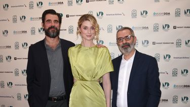 Los actores Claes Bong y Elizabeth Debicki, de The Burnt Orange Heresy, posan junto al director del filme, Giuseppe Capotondi, en la alfombra roja que inauguró el Miami Film Festival. 