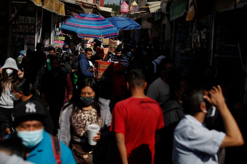 En imagen de archivo del 5 de enero de 2021, compradores y vendedores saturan una calle en un mercado informal en el centro de la Ciudad de México.