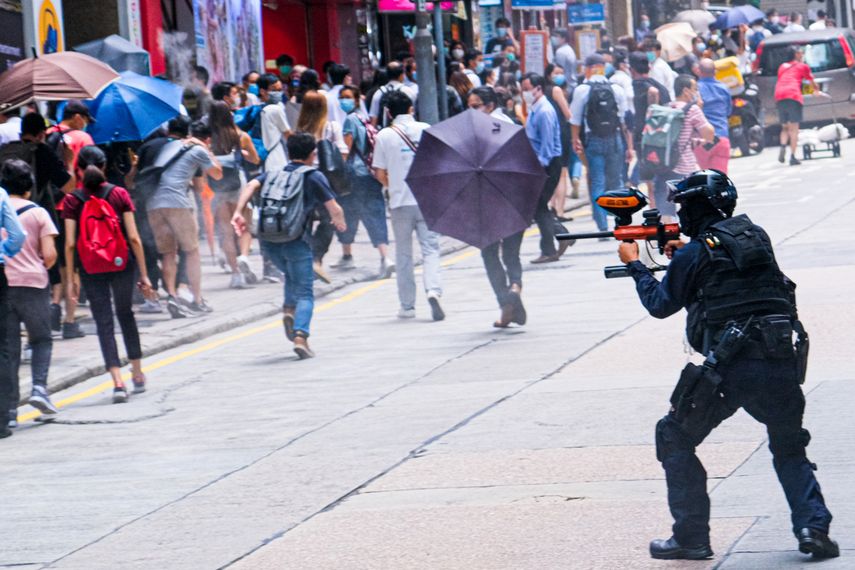 China, Hong Kong: un agente de la policía antidisturbios dispara proyectiles de gas pimienta a los manifestantes durante una manifestación contra la segunda lectura del Proyecto de Ley del Himno Nacional
