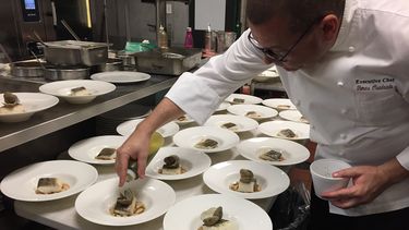 El chef Tomás Cuadrado deposita unas gotas de aceite oliva al estofado de alubias, con bacalao y almejas del Carril al vapor.