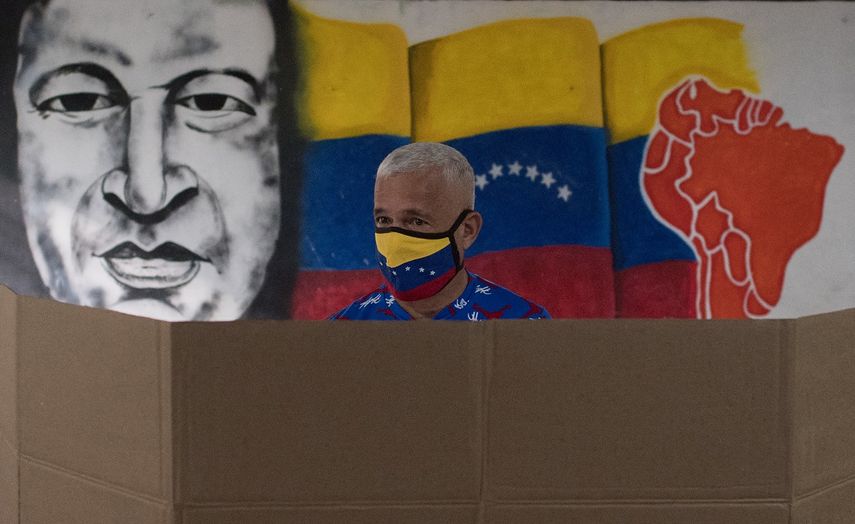 Un hombre con mascarilla prepara su papeleta en un colegio electoral de Caracas durante las elecciones regionales y municipales en Venezuela, el 21 de noviembre de 2021.&nbsp;&nbsp; &nbsp;
