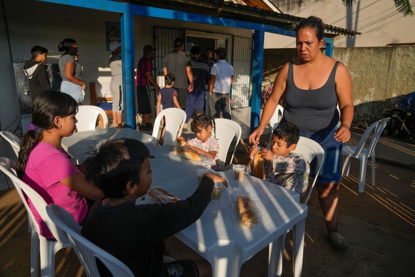 Natalia Contreras, una migrante venezolana, atiende a sus hijos mientras se preparan para desayunar en Rio Branco, Brasil, el 22 de junio de 2024. Migrantes, policías, funcionarios y analistas afirman que la decisión de Joe Biden de suspender temporalmente el asilo ha generado una actitud de espera entre los migrantes que están en Brasil y han paralizado sus planes de llegar a Estados Unidos.&nbsp;