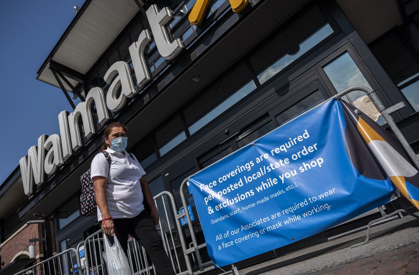 Una mujer pasa frente a la entrada de una tienda Walmart en EEUU.