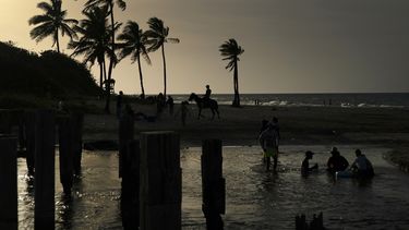 Un grupo de cubanos refresca en una playa del litoral norte de La Habana en un verano lleno de apagones y escaso de opciones recreativas.