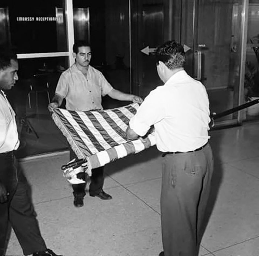 Funcionarios recogen la bandera estadounidese para abandonar la embajada de Estados Unidos en Cuba, el 3 de enero de 1961. (CORTESÍA)