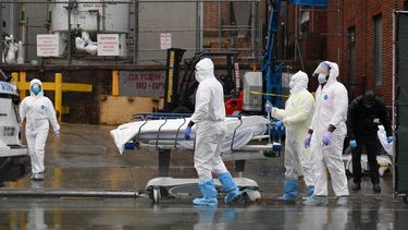 Paramédicos trasladan a uno de los fallecidos por COVID-19 a la morgue.