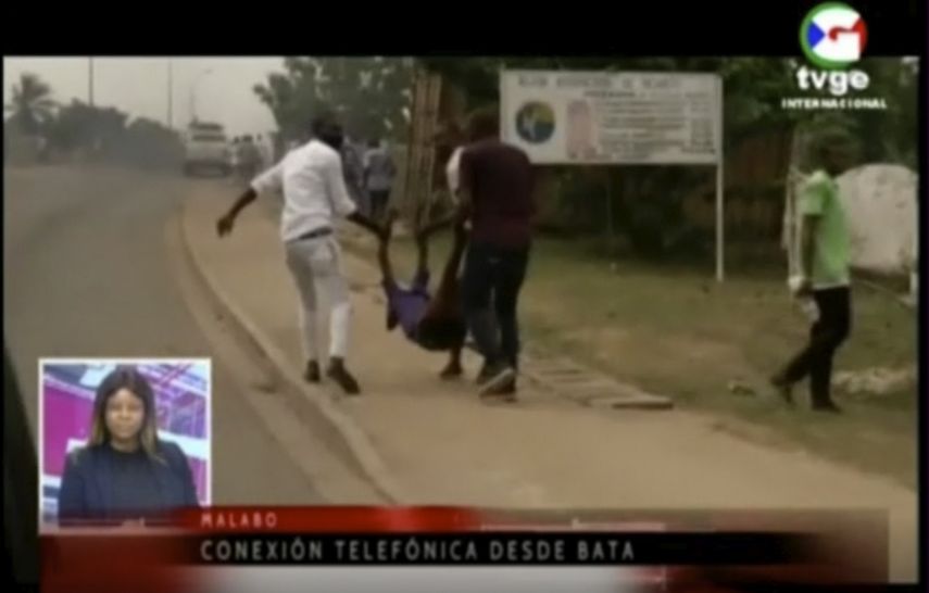 En esta imagen de TVGE tomada de un video muestra a dos personas trasladando a una víctima tras una explosión en un cuartel militar en Bata, Guinea Ecuatorial, el 7 de marzo de 2021.&nbsp;