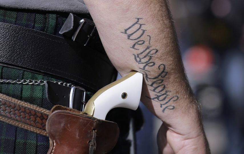 Fotografía de archivo del 26 de enero de 2015 de un partidario de las leyes de posesión libre de armas de fuego con una pistola mientras se prepara para un evento a favor del derecho de posesión en el Capitolio, en Austin, Texas.&nbsp;