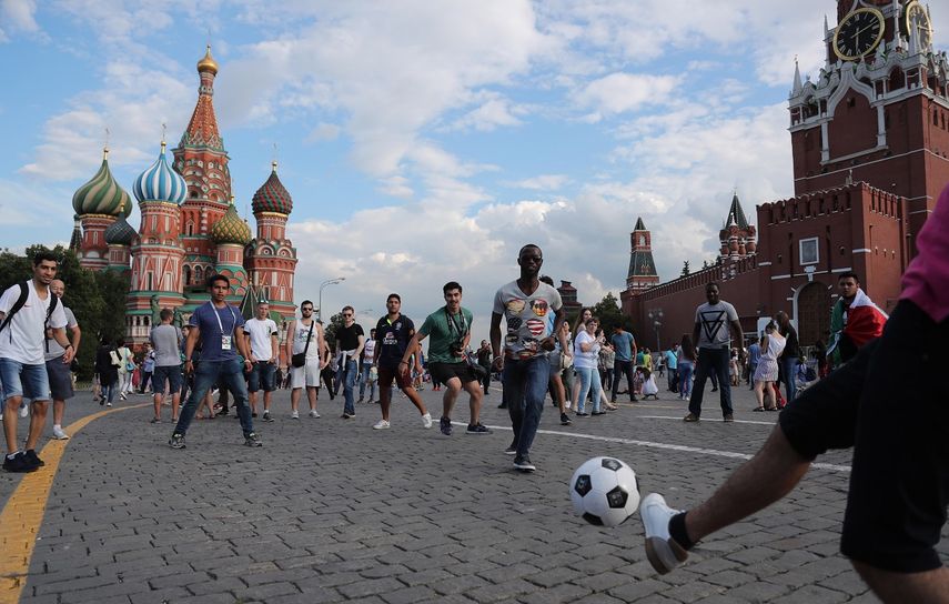 Un grupo de aficionados juega con un balón de fútbol en la Plaza Roja de Moscú.