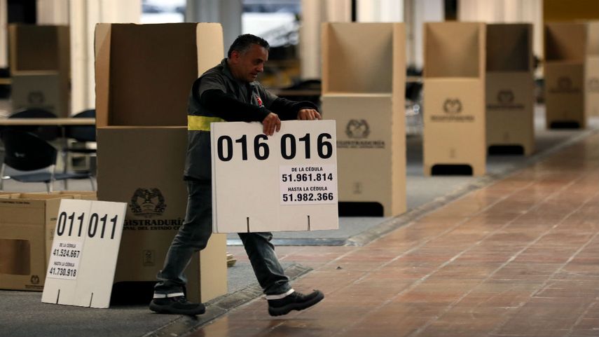 Un hombre organiza las mesas de votación en el colegio electoral que se instala en Corferias, Bogotá.