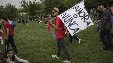 Un manifestante lleva una bandera con las palabras Ahora o nunca por el Parque OHiggins durante un concierto contra el gobierno en Santiago de Chile, el domingo 27 de octubre de 2019.&nbsp;