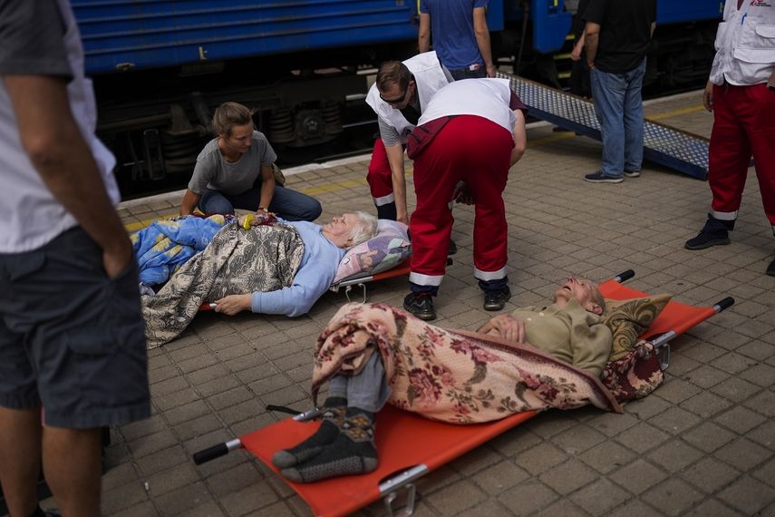 Pacientes ancianos en camillas esperan a subir a un tren de evacuación médica de Médicos Sin Fronteras en la estación de tren en Pokrovsk, en el este de Ucrania, el domingo 29 de mayo de 2022. Esperan en sillas de ruedas y en camillas, en ambulancias y en andenes de estación. Personal médico coloca rampas y lleva a los pacientes al tren medicalizado que los llevará al oeste, lejos de los combates que asolan el este de Ucrania.&nbsp;