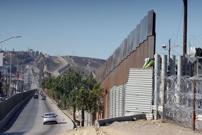 Obreros de migración de EEUU refuerzan las barreras de alambres de acero a lo largo de la línea fronteriza con la ciudad de Tijuana, México.