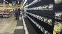 Unas personas caminan por pasillos con estantes vacíos en una tienda de Safeway, el martes 11 de enero de 2022, en Washington. 