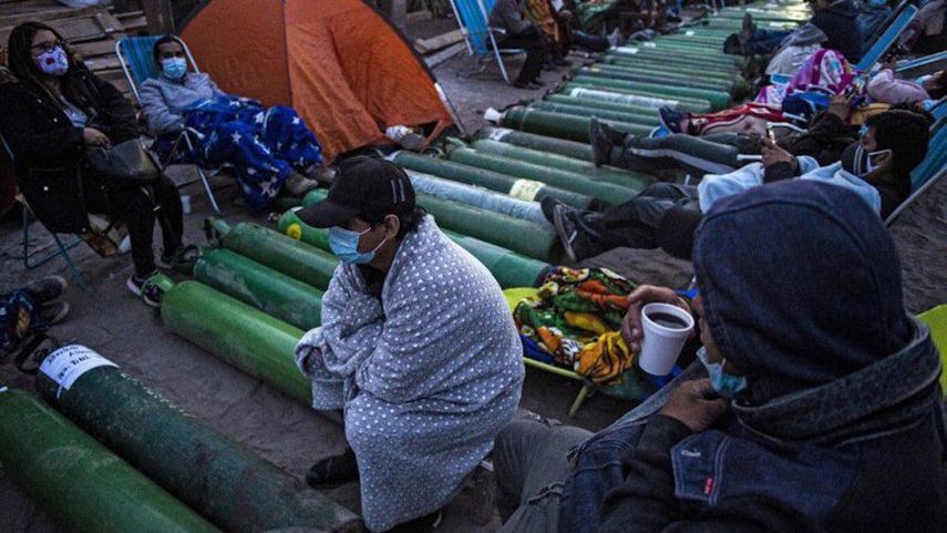 Personas acampan mientras esperan para rellenar cilindros de oxígeno vacíos en Villa El Salvador, en las afueras del sur de Lima, Perú, el 25 de febrero de 2021, en medio de la pandemia del coronavirus COVID-19. &nbsp; &nbsp;