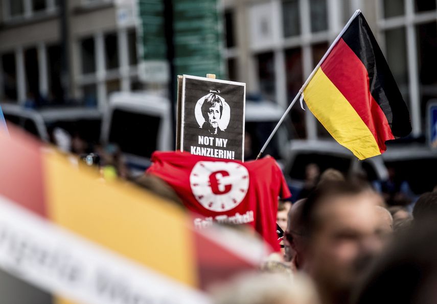 Manifestantes rechazan la candidatura de la actual canciller alemana Angela Merkel.&nbsp;